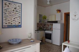 - une cuisine avec des placards blancs et un comptoir avec un bol dans l'établissement SeaHome, à Riposto