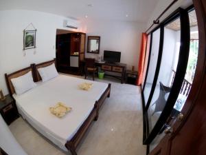Alona Vida Beach Resort في بنغلاو: غرفة نوم مع سرير وغرفة معيشة