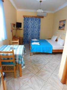 a bedroom with a bed and a table and a bed and a tv at To Spiti Tis Eirinis in Poros