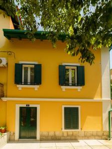 une maison jaune avec volets verts dans l'établissement Dalmat Apartment, à Split
