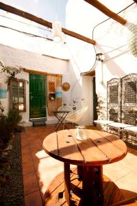 a patio with a wooden table and a green door at Casa Valle de Palmeras in Haría