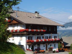 a large white building with red flowers on it at Gästehaus Maria in Kartitsch