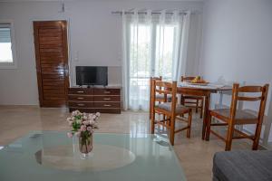a living room with a vase of flowers on a table at Ari's Apartment in Vonitsa