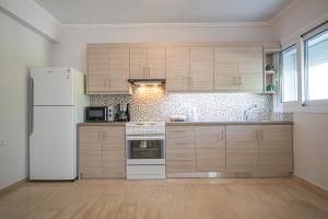 a kitchen with wooden cabinets and a white refrigerator at Ari's Apartment in Vonitsa