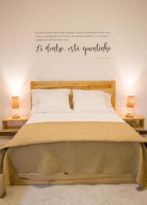 un letto in una stanza con due lampade e parole sul muro di Apartamento Xandinha Amwilla Guesthouse a Mindelo