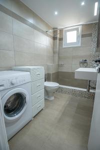 a bathroom with a washing machine and a toilet at Ari's Apartment in Vonitsa