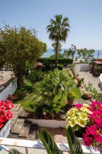 a garden with flowers and palm trees and the ocean at B&B L'ORIZZONTE in Crotone