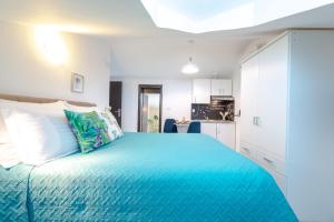 a bedroom with a large blue bed with white cabinets at Apartments Grgich in Dubrovnik