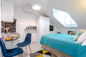 a bedroom with a bed and two blue chairs at Apartments Grgich in Dubrovnik
