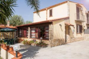 a house with a palm tree in front of it at Villa enza in Cinisi