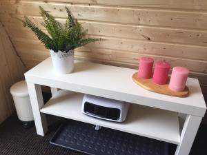 un escritorio blanco con una planta y dos tazas rosas en Triangle Cabin, en Laitila