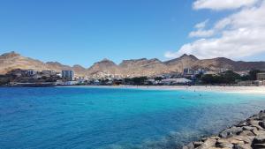 una spiaggia con un gruppo di persone in acqua di Apartamento Xandinha Amwilla Guesthouse a Mindelo