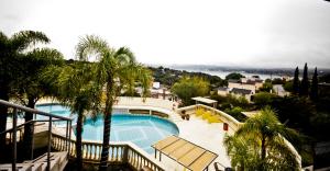 a view of a swimming pool with palm trees at Villa La Font Apart Hotel & Spa in Villa Carlos Paz