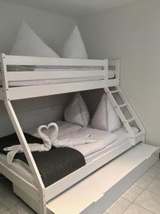 een wit stapelbed met witte kussens erop bij FeWo Marussia in Rust