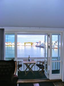 balcón con mesa y vistas al agua en Åkrehamn Marina en Åkrehamn