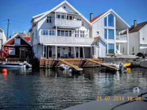 a large white house on the water with boats in it at Åkrehamn Marina in Åkrehamn