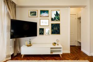 a living room with a flat screen tv on a wall at Emerald Oasis in Bucharest