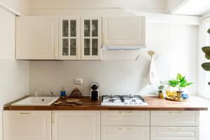 a kitchen with white cabinets and a stove top oven at Emerald Oasis in Bucharest