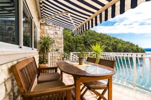 eine Terrasse mit einem Tisch und Stühlen auf dem Balkon in der Unterkunft Villa Smokvina in Bogomolje