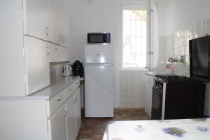 シオーフォクにあるEvelin Nyaralóházの白いキッチン(冷蔵庫、電子レンジ付)
