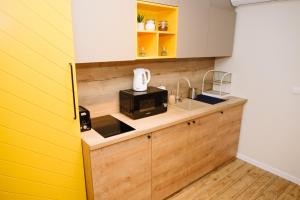 a kitchen with a yellow and white wall at Apartman Donner Centar II in Subotica