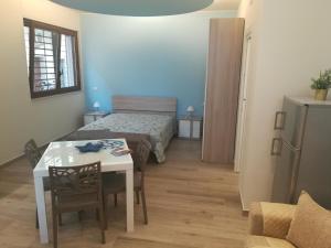 a small room with a bed and a table and a room at Casa Mirtillo in Bernalda