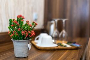 un jarrón con flores rojas sobre una mesa de madera en Ornament Hotel en Tiflis
