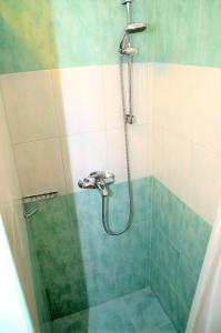 a bathroom with a shower with green and white tiles at Apartment Renata in Lovran +12 photos