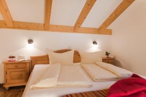 a bedroom with a large white bed with two lights at Törggelehof in Lagundo