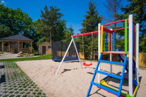 a playground with a slide and a swing at Niebieski Zakątek in Wisełka