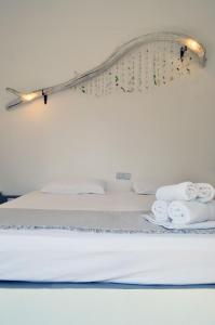 a bed with white sheets and towels on it at Paleochori Studios in Paliochori +26 photos