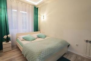 a bedroom with a bed with green curtains and a window at Apartament Hrabiego Centrum in Zakopane