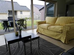 una sala de estar con un sofá y una mesa en Vakantievilla Aan Zee, en Middelkerke