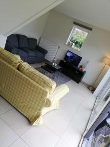 Una sala de estar con un sofá y un televisor. en Vakantievilla Aan Zee, en Middelkerke 17 fotos más