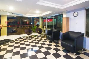 - une salle d'attente avec des chaises et un sol en damier dans l'établissement Hotel Igapó, à Londrina