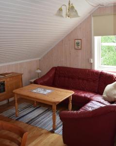 a living room with a red couch and a wooden table at Hesthaug Gard in Eidsdal