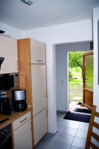a kitchen with a refrigerator and a door to a yard at Bungalow am Forsthaus Stagnieß in Ueckeritz