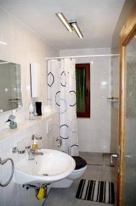 a white bathroom with a sink and a toilet at Bungalow am Forsthaus Stagnieß in Ueckeritz