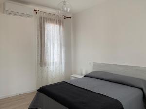a white bedroom with a bed and a window at Casa Roberta in Venice