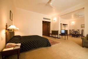 1 dormitorio con 1 cama y sala de estar en Hotel Express Residency-Jamnagar en Sika