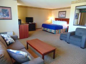a hotel room with a bed and a living room at Horse Creek Inn in McCook