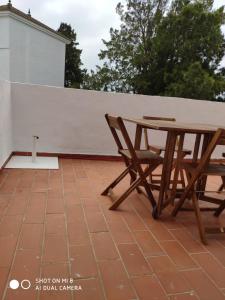 einen Picknicktisch und Stühle auf einer Terrasse in der Unterkunft ApartaClub la Barrosa in Chiclana de la Frontera