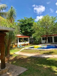 un patio trasero con piscina y una casa en Ch'ejum bungalow en Cancún