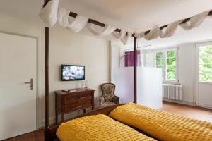 a bedroom with a large bed with a yellow blanket at Kulturhotel Guggenheim in Liestal