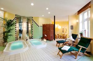 y baño grande con bañera y ducha. en Ringhotel VITALHOTEL ambiente, en Bad Wilsnack