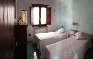 pokój hotelowy z dwoma łóżkami i oknem w obiekcie Villetta panoramica w mieście Maratea