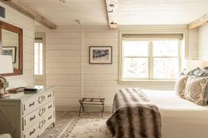 a bedroom with a bed and a dresser and a window at Eleven Scarp Ridge Lodge in Crested Butte