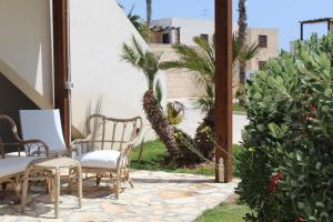 a patio with tables and chairs and plants at Boa Vista Favignana - Nuova Gestione 2026 in Favignana
