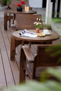 a wooden table and chairs with a plate of food on it at Lub Sbuy Hostel in Phuket