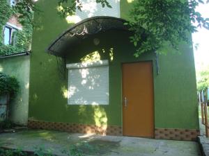 um edifício verde com uma porta e uma janela em Domik s saunoy na Ogiyenko em Kamianets-Podilskyi